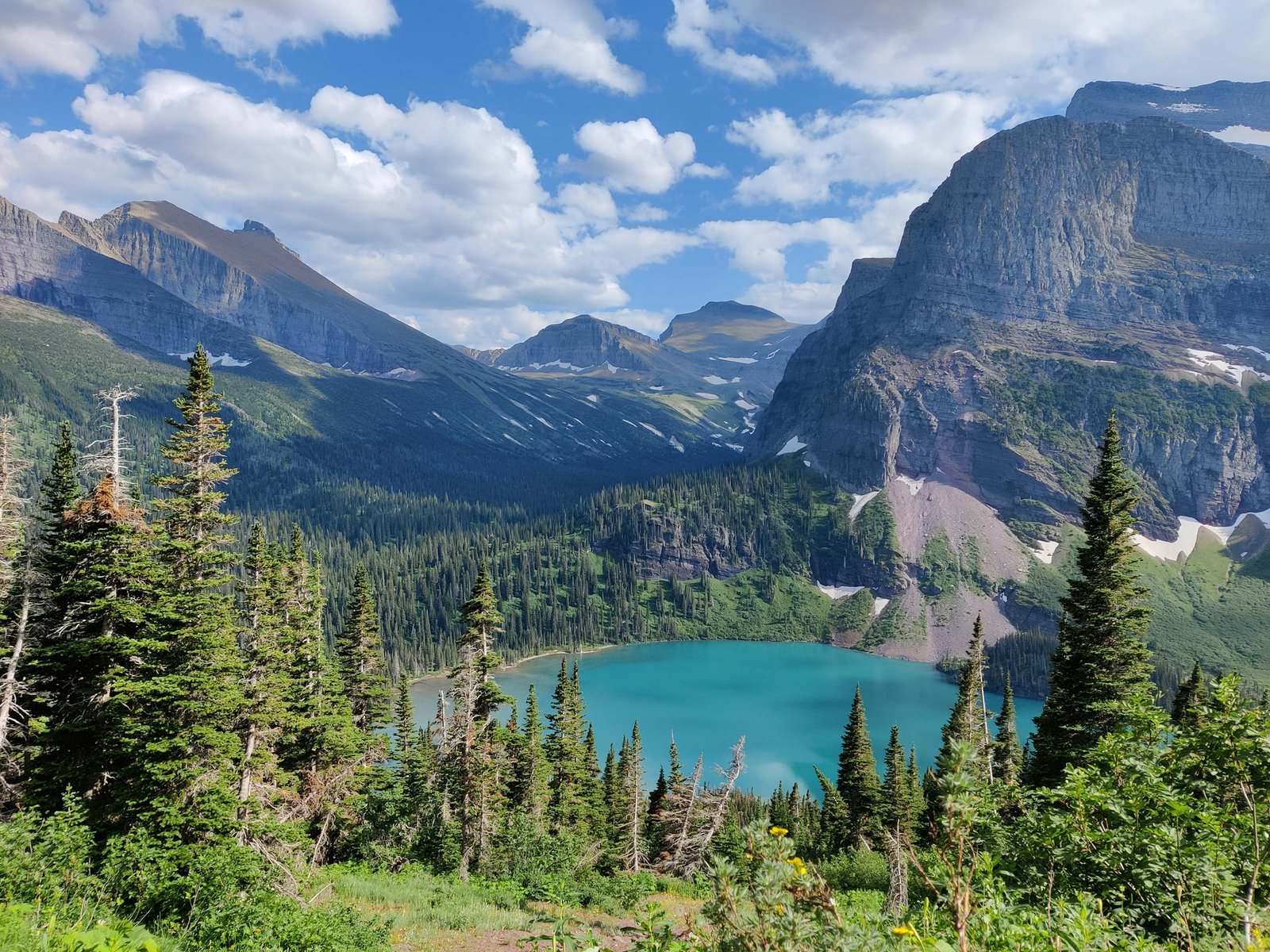 Breathtaking view of a mountain lake surrounded by forest in Glacier National Park, Montana.